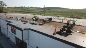 Construction crew performing roofing work on a large commercial building in Omaha