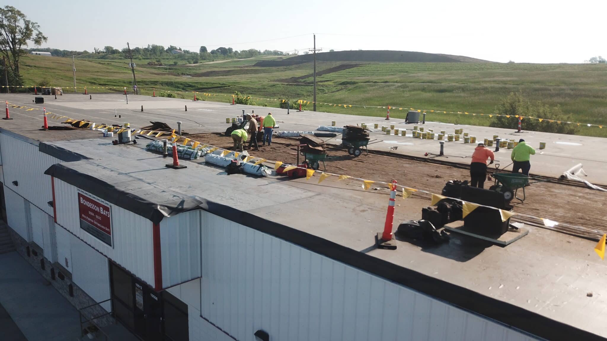 Construction crew performing roofing work on a large commercial building in Omaha
