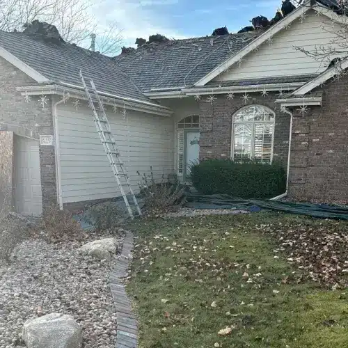 Residential home undergoing roof replacement with impact resistant shingles, work in progress by Anchor Roofing