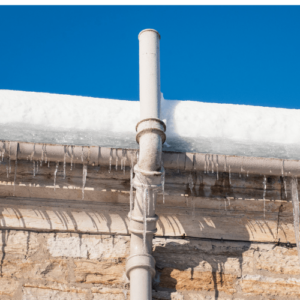 Icy gutter with icicles hanging, against a clear blue sky.