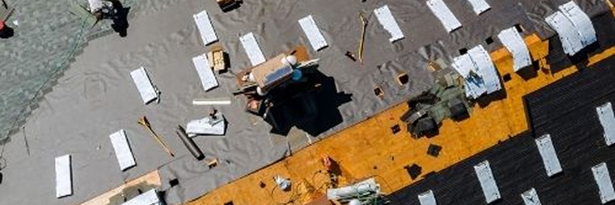 Roofers measuring and installing shingles to calculate roof square footage by Anchor Roofing in Omaha, Nebraska