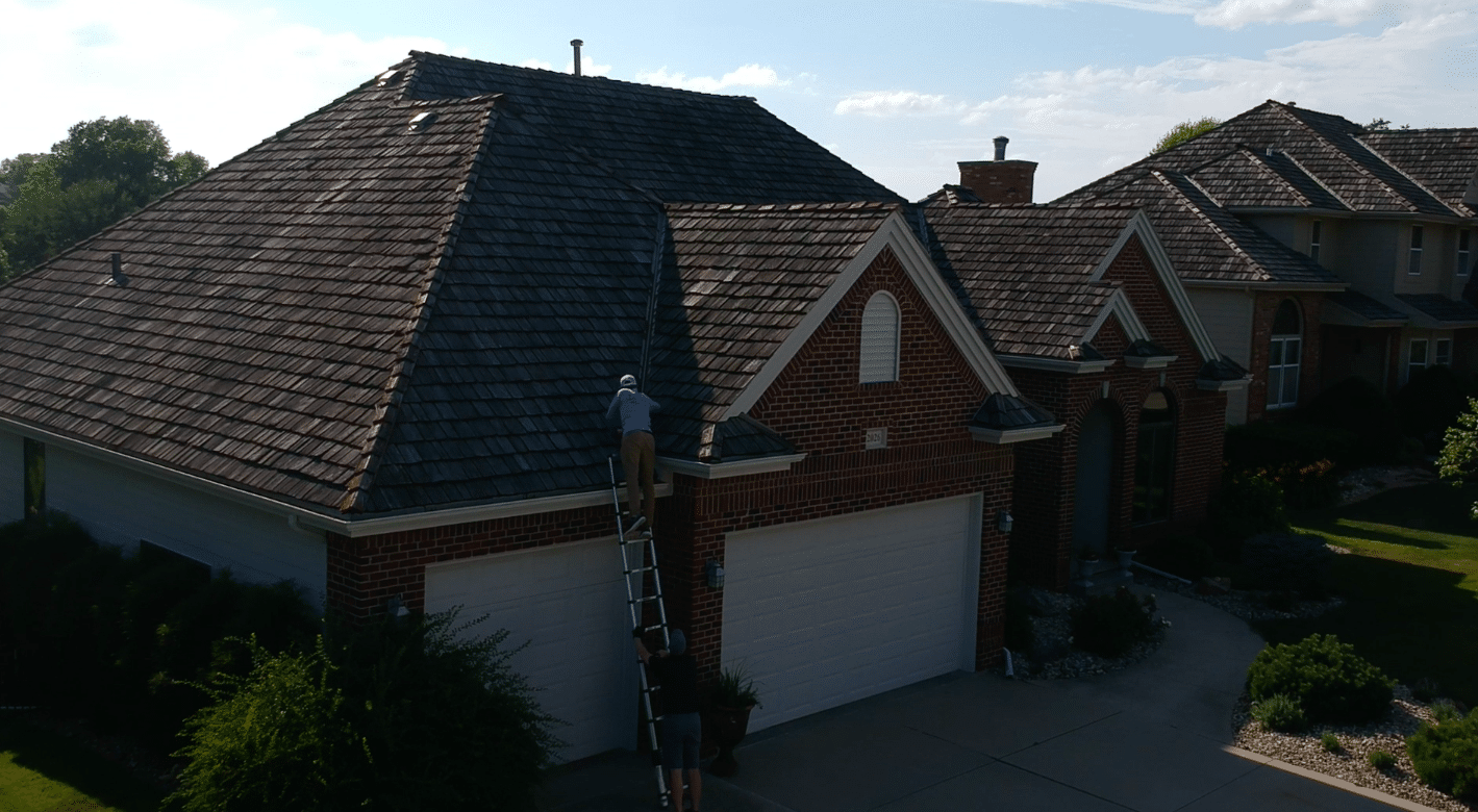 A contractor inspecting a roof with a ladder at a residential home, showing roof replacement work in Omaha, Nebraska.