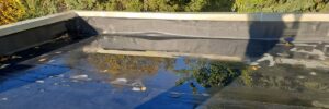 outdoor shot shows a flat roof surface with a dark EPDM that is on process of roof repair omaha, NE