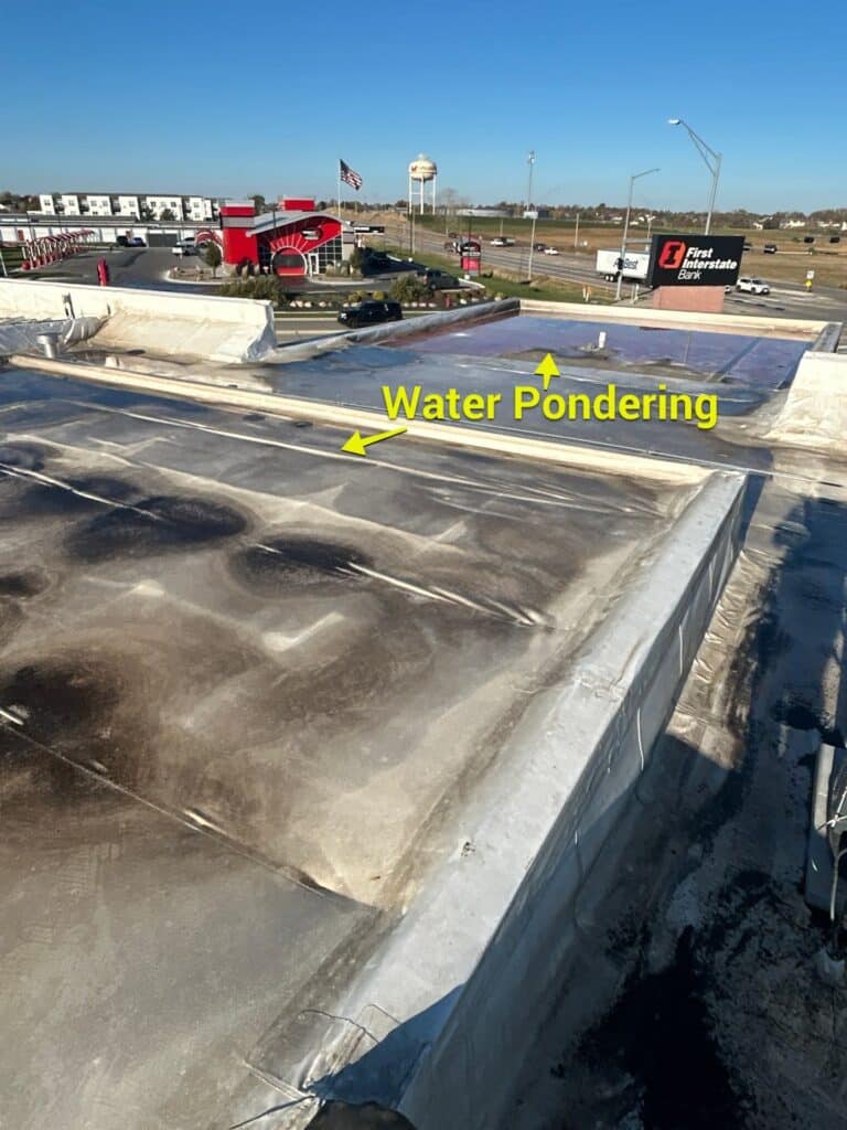 Flat roof inspection showing water ponding areas by Anchor Roofing in Omaha, NE