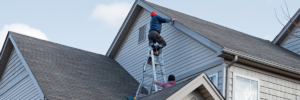 Roofing crew installing a valley gutter system on a residential roof