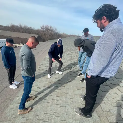 Anchor Roofing team examining roof shingles for inspection process demonstration by Anchor Roofing in Omaha, NE