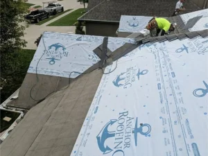 Anchor Roofing crew members installing new shingles and branded underlayment, representing anchor roofing community support by Anchor Roofing
