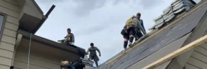 Anchor Roofing crew replacing damaged roof for leak repair, workers installing new shingles on residential home