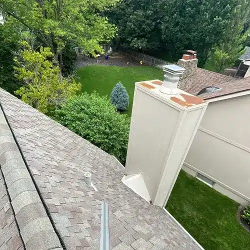 Roof valley and chimney flashing on shingle roof inspected for leaks and water intrusion, illustrating roof leak replacement by Anchor Roofing