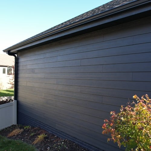 Dark gray composite siding on residential exterior by Anchor Roofing in Omaha, NE