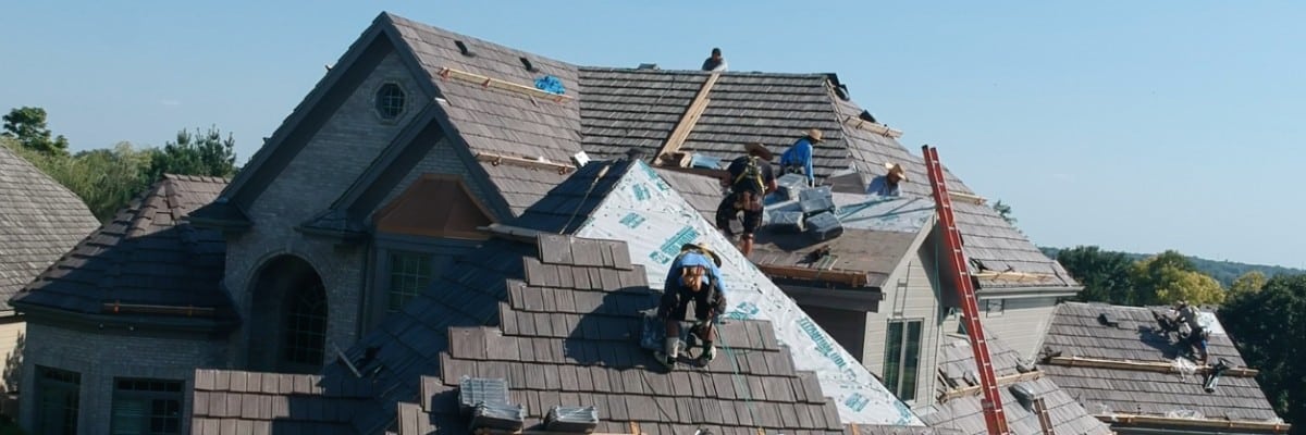 Large home under simultaneous siding installation and roof repair by Anchor Roofing in Omaha, Nebraska