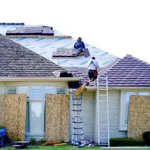 Team working on siding installation alongside new roof installation by Anchor Roofing in Omaha, Nebraska