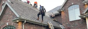 Roofing crew repairing lifted asphalt shingles after ice and snow—cold weather roof damage Nebraska by Anchor Roofing in Nebraska