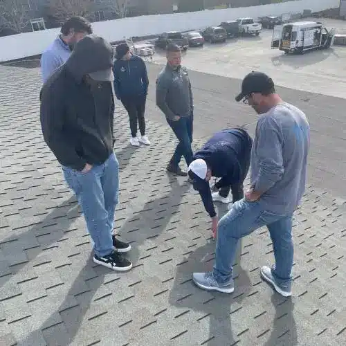 Roofing inspectors on a home roof examining shingles for winter-related issues like lifting and brittleness—cold weather roof damage Nebraska by Anchor Roofing in Nebraska
