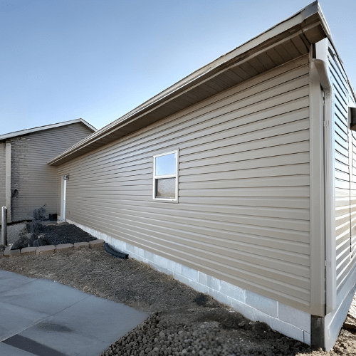 Newly installed beige vinyl siding on the side of a residential home in Nebraska with clean lines and finished foundation