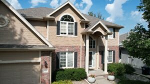 Before siding replacement showing faded, outdated MDF siding with visible wear and rot on Omaha home exterior by Anchor Roofing