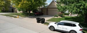 James Hardie siding installation on suburban home in Omaha NE with driveway, landscaping