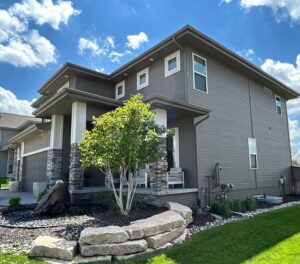 Front exterior of Omaha home with new siding and roof replacement by Anchor Roofing improving curb appeal and overall home value