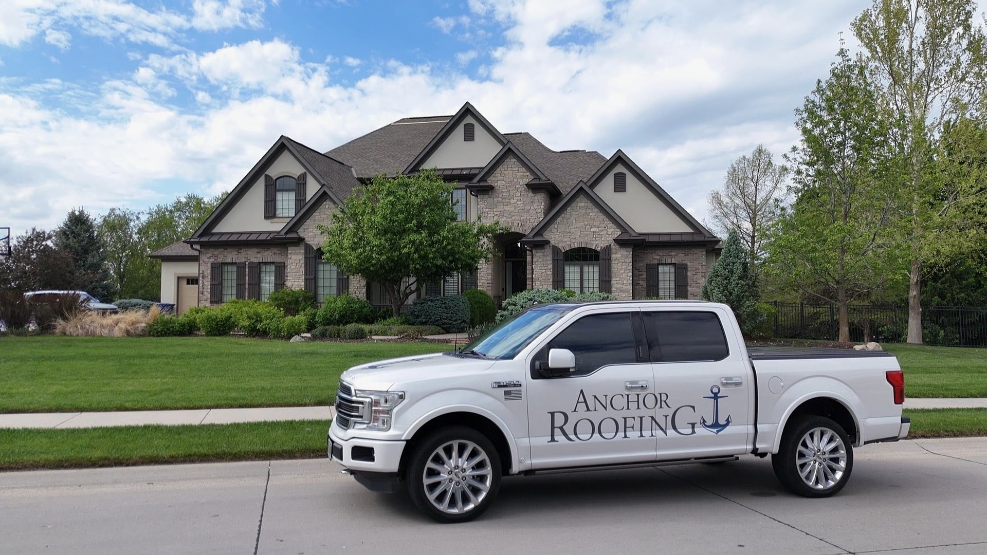 Anchor Roofing truck in front of a home with a roof replacement completed project in Omaha, NE