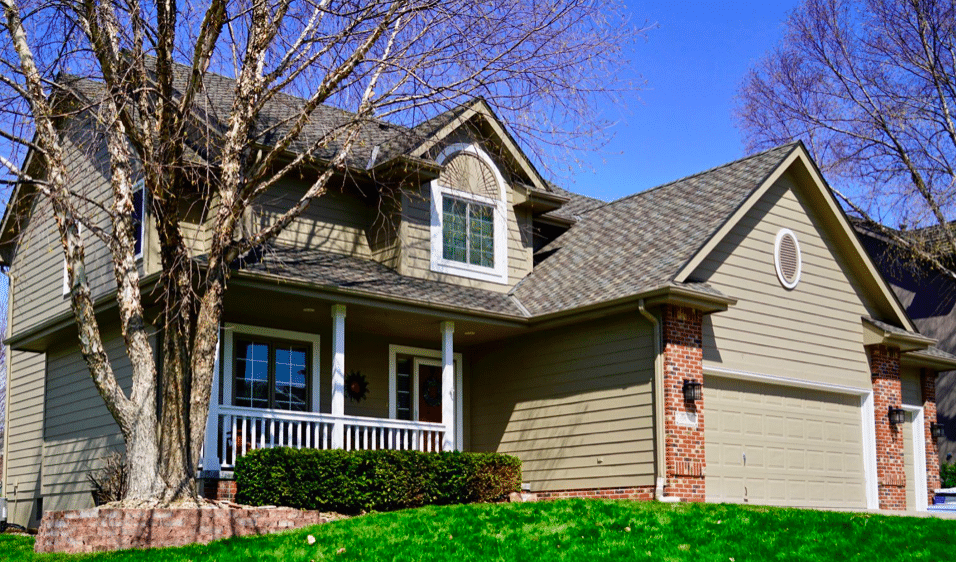 Owens Corning Platinum Preferred Contractor in Omaha showcasing a completed roof on a two‑story brick and siding home with front porch and garage