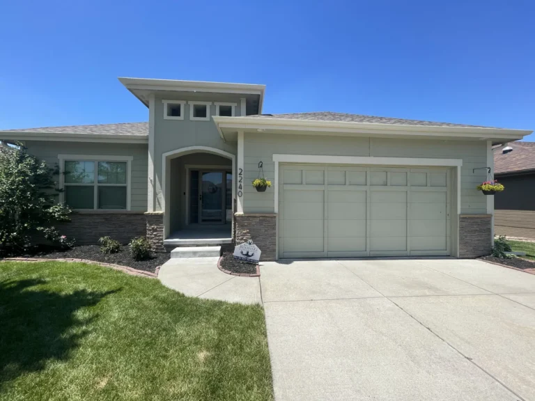 A beautiful Omaha home featuring a new roof installed by Anchor Roofing, with a neatly landscaped yard and inviting front entrance.
