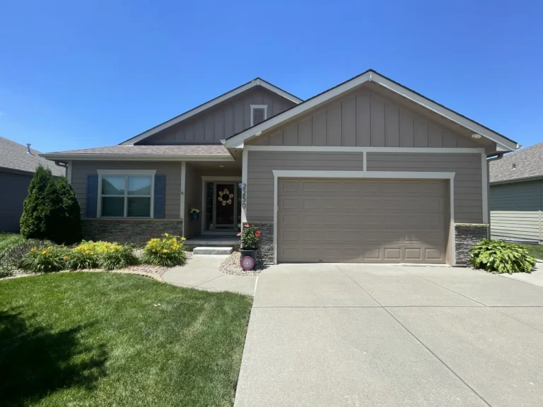 Front view of an Omaha home with a recently completed shingle roof, clean landscaping, and a well-maintained exterior by Anchor Roofing.