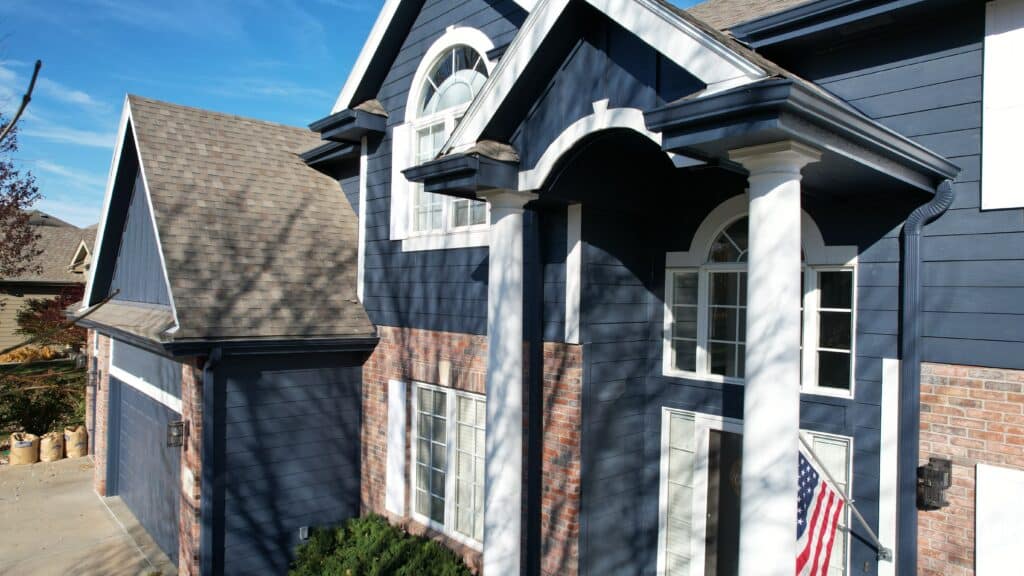 A finished home exterior with updated siding and trim, showing a top-rated siding installer in Omaha by Anchor Roofing.