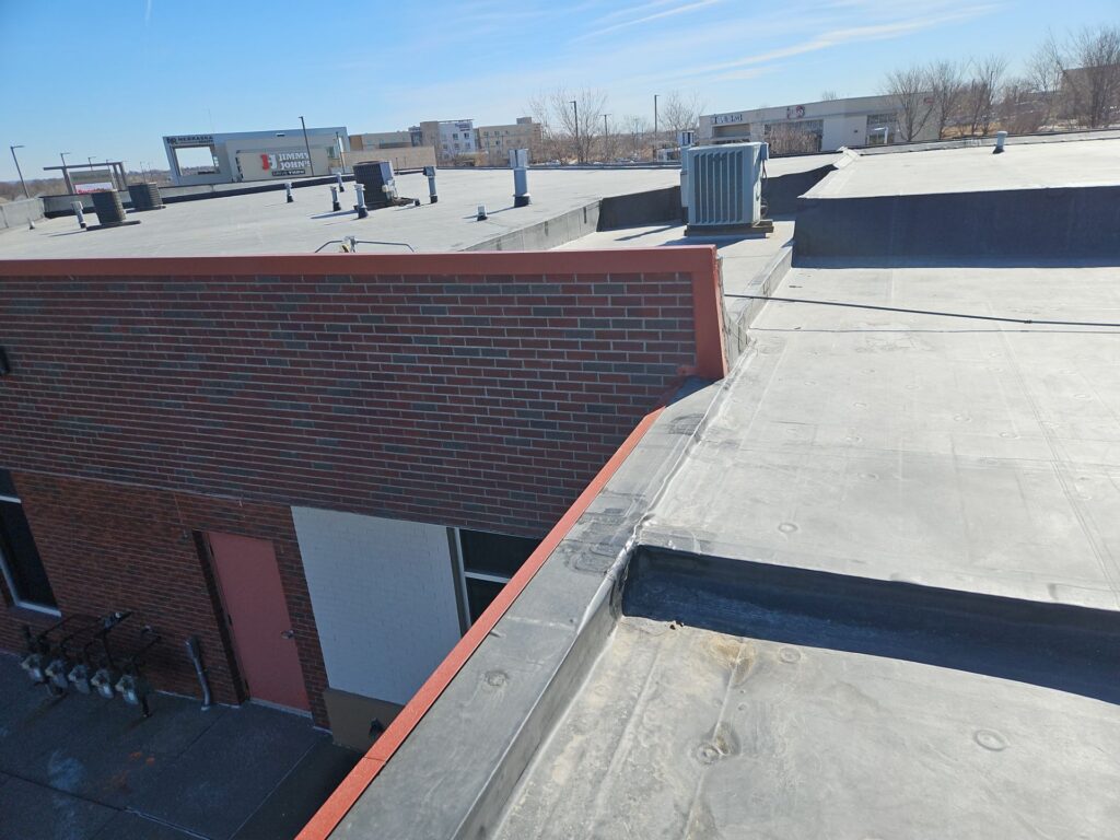 Wide view of a large commercial flat membrane roof system installed on a multi-family property for apartment roofing Omaha commercial flat roofing in Omaha by Anchor Roofing