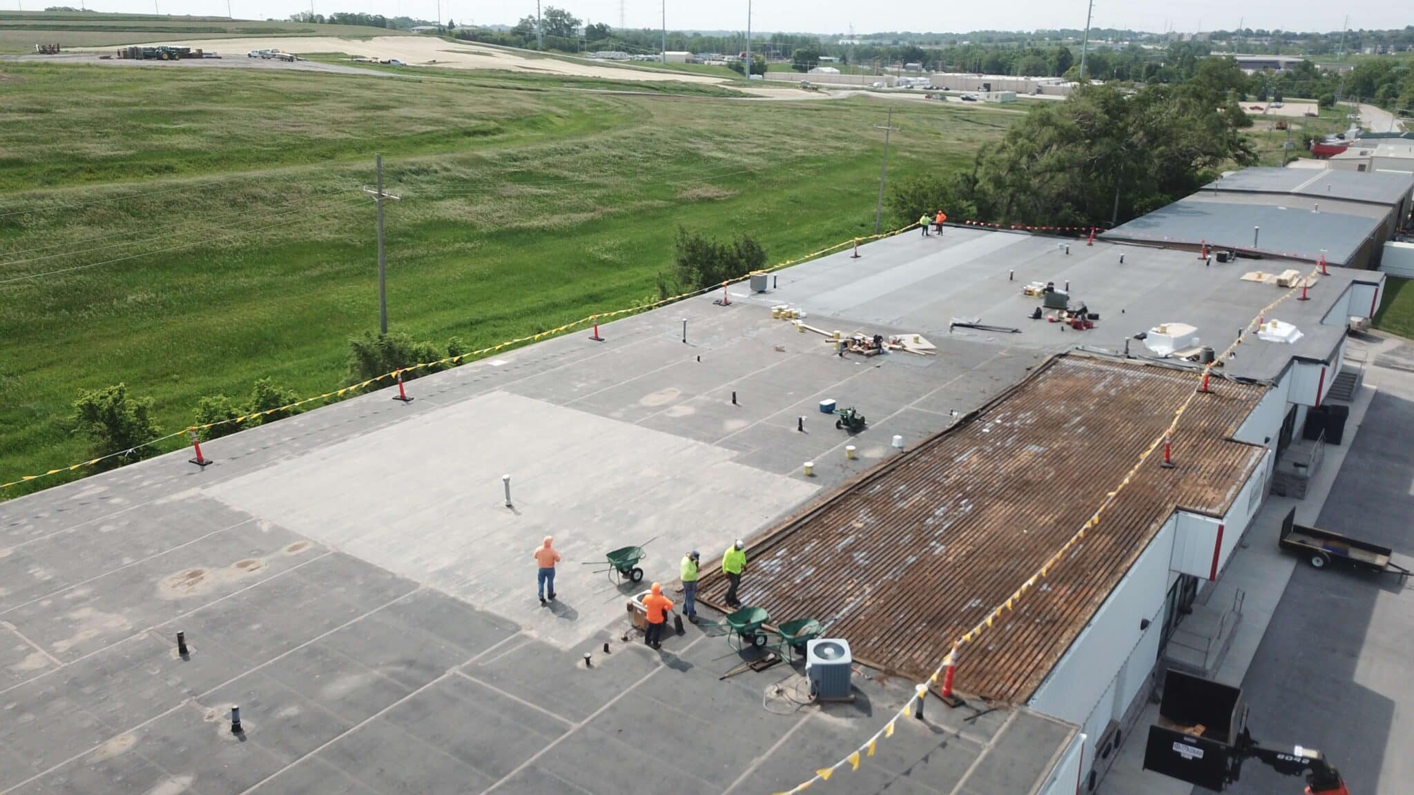 Workers performing property management roofing service in Omaha by Anchor Roofing