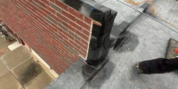Roofing contractors repairing a damaged commercial flat roof