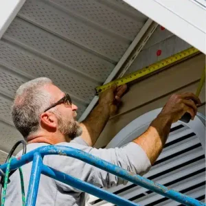 Professional siding contractor measuring and installing home siding by Anchor Roofing in Omaha