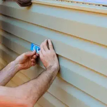 Skilled siding contractor from Anchor Roofing in Omaha ensuring accurate vinyl siding installation using professional tools for home exterior upgrades.